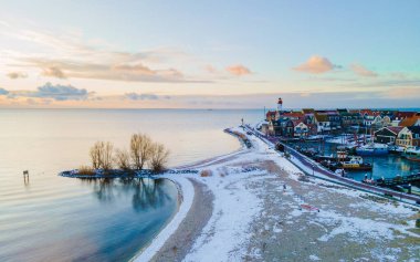 Kış boyunca Hollanda 'da kar manzaralı Urk deniz feneri. Kışın Hollanda köyü