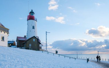 Kışın soğuk bir günde Hollanda 'da kar yağarken Urk Deniz Feneri.