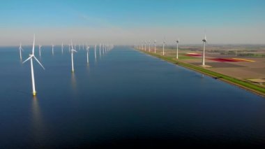 Hollanda 'da bahar boyunca yeşil enerji üreten yel değirmeni türbinlerinin insansız hava aracı görüntüsü.