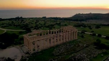 Selinunte, Temple, gün batımında Yunan ve Roma tapınaklarının insansız hava görüntüsü. Selinunte 'deki Yunan tapınakları, deniz manzarası ve Selinunte Arkeoloji Parkındaki Yunan sütunlarının kalıntıları