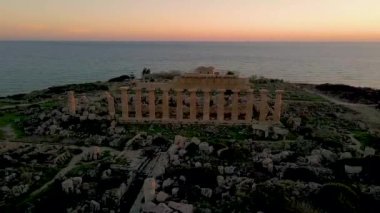 Selinunte, Temple, gün batımında Yunan ve Roma tapınaklarının insansız hava görüntüsü. Selinunte 'deki Yunan tapınakları, deniz manzarası ve Selinunte Arkeoloji Parkındaki Yunan sütunlarının kalıntıları