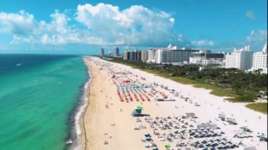 Miami South Beach Florida 'da insansız hava aracı görüntüsü. Renkli sandalyeli ve şemsiyeli plaj. Miami Florida