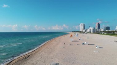 Miami South Beach Florida 'da insansız hava aracı görüntüsü. Renkli sandalyeli ve şemsiyeli plaj. Miami Florida