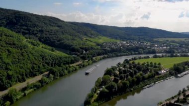 Berkastel dağlarında aydınlık bir yaz günü, Almanya 'daki Mosel nehri üzerinden iç kesimlere tekne gazı nakliyesi. Moselle nehrinde bir gaz tankeri var.