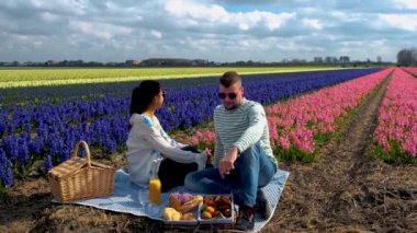 Hollanda 'daki bir çiçek tarlasında çiftler pikniği. Hollanda' da erkekler ve kadınlar çiçek tarlasında.