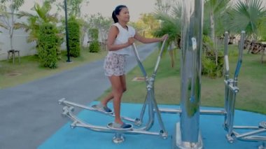 Pattaya Tayland 'da bir halk parkında Asyalı kadınlar spor yapıyor. Taylandlı olgun bir kadın şehirde palmiye ağaçlarıyla parkta egzersiz yapıyor.