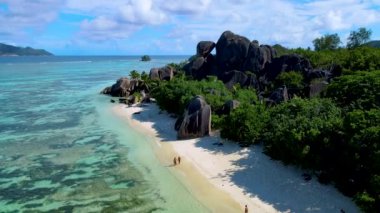 Anse Source DArgent sahilinde yürüyen iki erkek ve kadın Seyşeller 'deki en güzel plajdır. La Digue Adası, Seyşeller. 