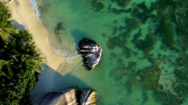 Anse Source DArgent plajında oturan bir çift kadın ve erkek Seyşeller 'deki en güzel plajdır. La Digue Adası, Seyşeller. 