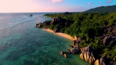 Anse Source DArgent sahilinde gün batımını izleyen iki erkek ve kadın Seyşeller 'deki en güzel plajdır. La Digue Adası, Seyşeller. 