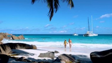 Praslin Adası 'ndaki Anse Lazio plajında bir çift. Seyşeller, turkuaz renkli bir okyanusa sahip.