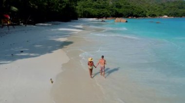 Praslin Adası Seyşeller 'deki Anse Lazio plajında yürüyen bir çift.,