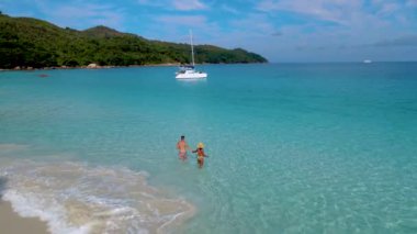 Praslin Adası Seyşeller 'deki Anse Lazio plajında mavi okyanusta bir çift.