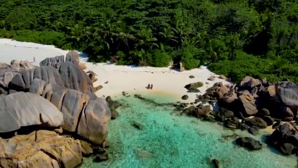 Anse Cocosビーチの男性と女性のカップルで上からの眺めセーシェルの白い砂とターコイズブルーの海がある美しいビーチ — ストック動画