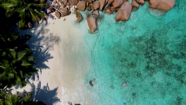 人々は プラスリン島セイシェルのAnseラツィオビーチのビーチでシュノーケリング Anse Petitラツィオビーチの湾の秘密の小さなビーチ プラスリン セイシェル — ストック動画