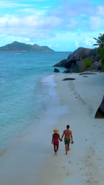 近日清晨 一对男女情侣在塞舌尔美丽的海滩Anse Source Dargent海滩上散步 塞舌尔 拉迪古岛 — 图库视频影像