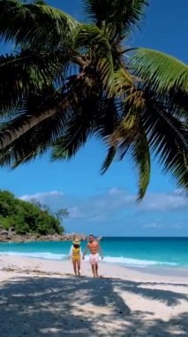 Praslin Adası 'ndaki Anse Lazio plajında bir çift. Seyşeller, turkuaz renkli bir okyanusa sahip.