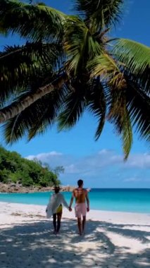 Praslin Adası 'ndaki Anse Lazio plajında bir çift. Seyşeller, turkuaz renkli bir okyanusa sahip.
