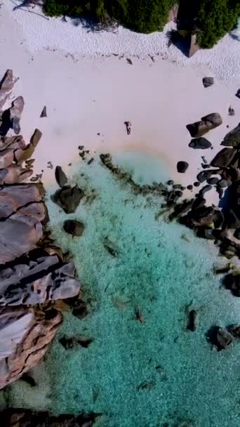 在Anse Cocos海滩上的男女情侣塞舌尔La Digue岛 Petite Anse海滩是一个美丽的海滩 有着白色的沙子和草皮色的海洋 — 图库视频影像