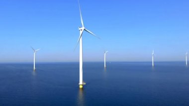 Bulutlu ve mavi gökyüzü olan yel değirmeni parkı, rüzgâr türbini Flevoland Hollanda 'nın deniz manzaralı yel değirmeni parkı. Yeşil enerji. 