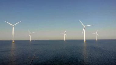 Bulutlu açık deniz yel değirmeni parkı ve mavi gökyüzü. Rüzgâr türbini Flevoland Hollanda 'nın deniz manzaralı yel değirmeni parkı. Yeşil enerji. 
