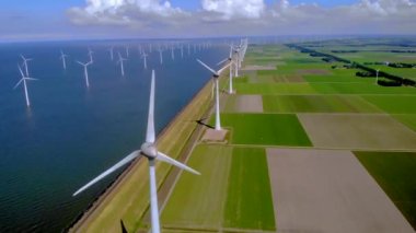 Kıyıdan uzak bir yel değirmeni parkı ve mavi bir gökyüzü, okyanus havası manzaralı rüzgar türbini Flevoland Hollanda Ijsselmeer ile. Yeşil enerji. 