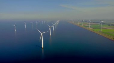 Açık deniz yel değirmeni parkı bulutlu ve mavi gökyüzü, okyanus havası manzaralı rüzgar türbini Flevoland Hollanda Ijsselmeer. Yeşil enerji kavramı