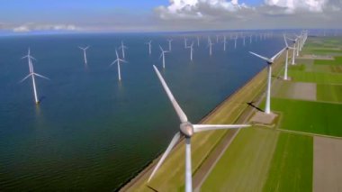 Bulutlu ve mavi gökyüzü olan yel değirmeni parkı, rüzgâr türbini Flevoland Hollanda 'nın deniz manzaralı yel değirmeni parkı. Yeşil enerji. 