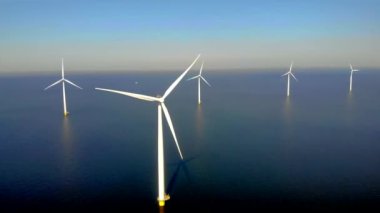 Kıyıdan uzak bir yel değirmeni parkı ve mavi bir gökyüzü, okyanus havası manzaralı rüzgar türbini Flevoland Hollanda Ijsselmeer ile. Yeşil enerji. 
