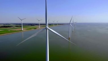 Açık deniz yel değirmeni parkı bulutlu ve mavi gökyüzü, okyanus havası manzaralı rüzgar türbini Flevoland Hollanda Ijsselmeer. Yeşil enerji kavramı