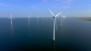 Kıyıdan uzak bir yel değirmeni parkı ve mavi bir gökyüzü, okyanus havası manzaralı rüzgar türbini Flevoland Hollanda Ijsselmeer ile. Yeşil enerji. 