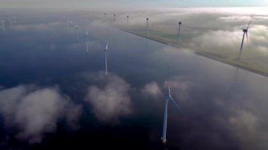 Kıyıdan uzak bir yel değirmeni parkı ve mavi bir gökyüzü, okyanus havası manzaralı rüzgar türbini Flevoland Hollanda Ijsselmeer ile. Yeşil enerji. 