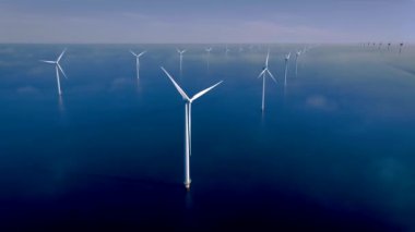 Kıyıdan uzak bir yel değirmeni parkı ve mavi bir gökyüzü, okyanus havası manzaralı rüzgar türbini Flevoland Hollanda Ijsselmeer ile. Yeşil enerji. 