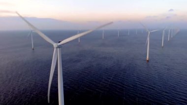 Gün batımında açık deniz yel değirmeni parkı, okyanus manzaralı yel değirmeni parkı rüzgar türbini Flevoland Hollanda Ijsselmeer. Yeşil enerji. 