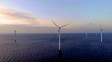 Gün batımında açık deniz yel değirmeni parkı, okyanus manzaralı yel değirmeni parkı rüzgar türbini Flevoland Hollanda Ijsselmeer. Yeşil enerji. 