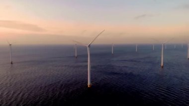 Gün batımında açık deniz yel değirmeni parkı, rüzgâr türbini Flevoland Hollanda Ijsselmeer ile okyanus havası manzaralı yel değirmeni parkı. Yeşil enerji. 