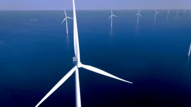 Bulutlu ve mavi gökyüzü olan yel değirmeni parkı, okyanus havası manzaralı rüzgar türbini Flevoland Hollanda Ijsselmeer