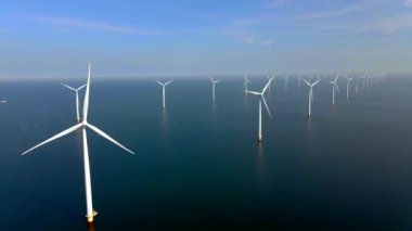 Açık deniz yel değirmeni parkı, bulutlar ve mavi gökyüzü, okyanus havadan rüzgar türbini Flevoland Hollanda 'nın Ijsselmeer' ini gören yel değirmeni türbinleri. Yeşil enerji. 