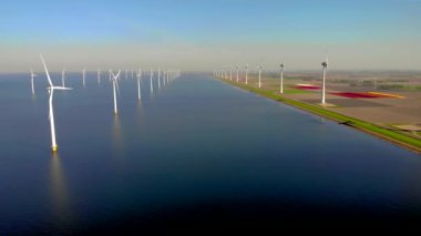 Bulutlu ve mavi gökyüzü olan yel değirmeni parkı, rüzgâr türbini Flevoland Hollanda 'nın deniz manzaralı yel değirmeni parkı. Yeşil enerji. 