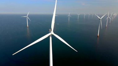 Bulutları ve mavi gökyüzü olan off-shore yel değirmeni parkı, rüzgar türbini Flevoland Hollanda 'nın deniz manzaralı yel değirmeni parkı Ijsselmeer. Yeşil enerji. 