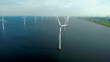 Bulutları ve mavi gökyüzü olan off-shore yel değirmeni parkı, rüzgar türbini Flevoland Hollanda 'nın deniz manzaralı yel değirmeni parkı Ijsselmeer. Yeşil enerji. 