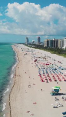 Miami South Beach Florida 'da. Güneşli bir günde renkli sandalyeli ve şemsiyeli plaj