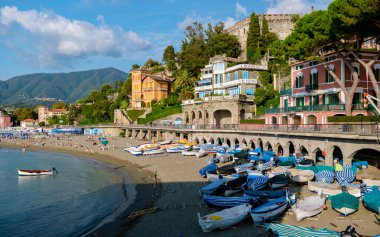 Cinque Terre İtalya Eylül 2018, İtalya 'da Levanto Cinque Terre renkli köy, yaz tatilinde şemsiyeli ve balıkçı tekneli renkli plaj. 