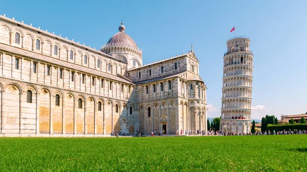 stock image Leaning tower of Pisa, Italy with Basilica and Cathedral on a bright summer day with green grass low angle. 