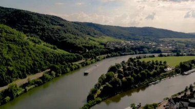 Dağlarda üzüm bağları bulunan Bernkastel dağlarında aydınlık bir yaz günü, Almanya 'da Moselle nehri üzerinden iç kesimlere doğalgaz taşımacılığı. Mosel nehrinde gaz tankeri var.