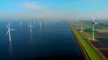 Denizdeki yel değirmeni türbinleri Hollanda 'da yeşil enerji üretir. Yaz boyunca okyanustaki yel değirmeni parkında insansız hava aracı görüntüsü