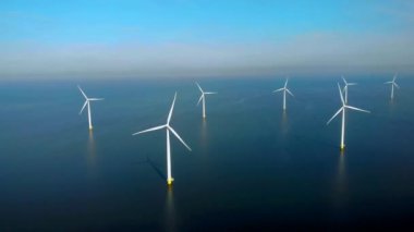 Denizdeki yel değirmeni türbinleri Hollanda 'da yeşil enerji üretir. Mavi gökyüzü olan yel değirmeni parkında İHA görüntüsü