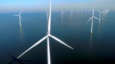 Denizdeki yel değirmeni türbinleri Hollanda 'da yeşil enerji üretir. Mavi gökyüzü olan yel değirmeni parkında İHA görüntüsü