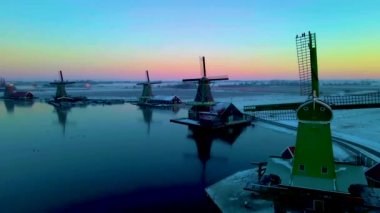 Zaanse Schans Hollanda 'nın yel değirmeni köyünü kaplayan kar, kış mevsiminde Zaanse Schans Hollanda' nın tarihi ahşap yel değirmenleri.