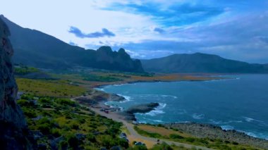 San Vito Lo Capo Sicilya, San Vito lo Capo plajı, ve Monte Monaco arka planda, kuzey batı Sicilya. Sicilya 'da yaz boyunca kayalık ve kayalık kıyı şeridi