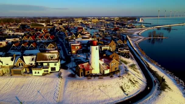 在前岛屿Urk Flevoland Netherlands旁边的Ijsselmeer湖石滩上的Urk灯塔边的冬季雪地天气 — 图库视频影像